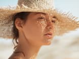 Frau mit Sonnencreme unter Make-up