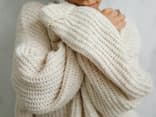 Eine Frau trägt einen selbst gestrickten Pullover aus warmer Wolle
