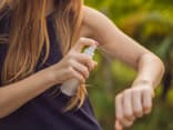 Frau sprüht sich mit selbst gemachtem Zeckenspray ein