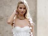 Frau trägt eine Kette und ein weißes Kleid 