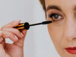 Frau trägt wasserfeste Mascara auf ihre Wimpern auf