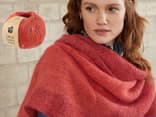 Eine Frau im selbstgestrickten Poncho mit Wolle von Lana Grossa