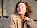 Model mit beiger Strickjacke mit Schalkragen von Lana Grossa