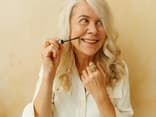 Frau verwendet Anti-Aging-Mascara mit Hyaluron