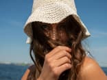 Frau mit bester Sonnencreme für empfindliche Haut im Gesicht