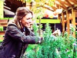 Eine Frau arbeitet in ihrem Garten - welche Geräte dabei nicht fehlen sollten, erfahren Sie hier 
