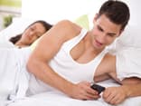 Mann und Frau liegen zusammen im Bett - Betrügt er sie?