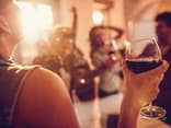 Frau trinkt ein Glas Rotwein. Gegen einen Kater helfen diese Tipps. 